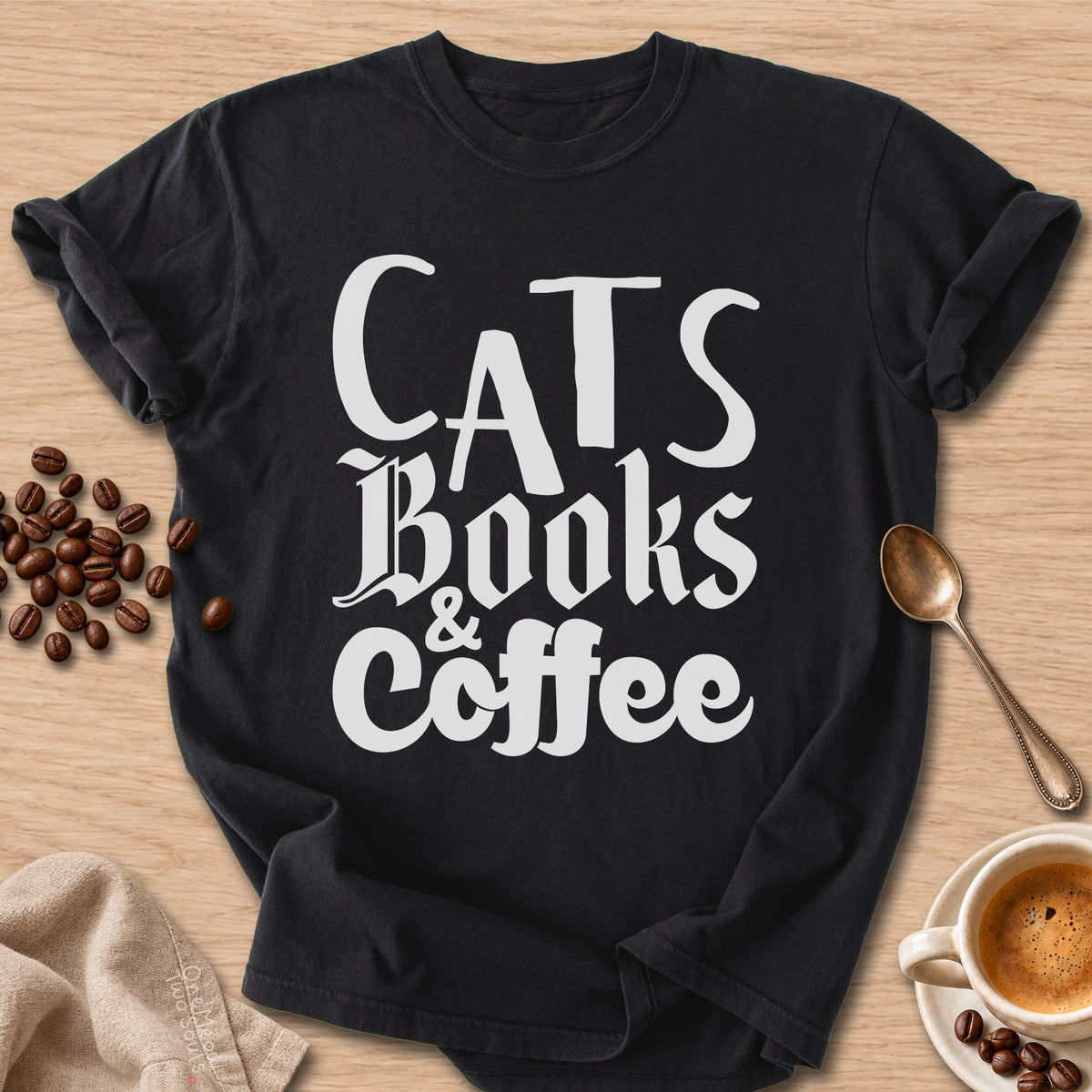 Black colored Comfort Colors 1717 cotton T-shirt, featuring a "Cats, Books & Coffee" funny cat design illustration. One Meow Two Souls brand.