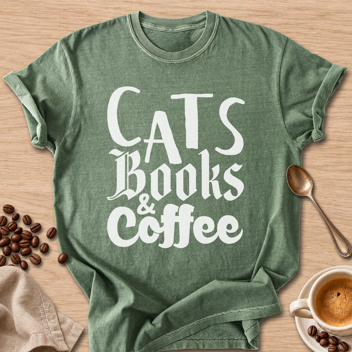 Moss colored Comfort Colors 1717 cotton T-shirt, featuring a "Cats, Books & Coffee" funny cat design illustration. One Meow Two Souls brand.