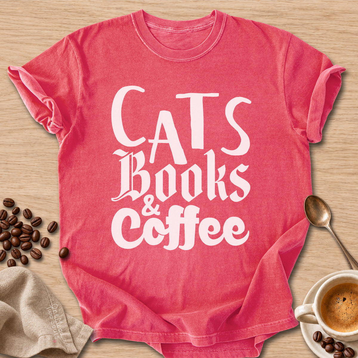 Watermelon colored Comfort Colors 1717 cotton T-shirt, featuring a "Cats, Books & Coffee" funny cat design illustration. One Meow Two Souls brand.