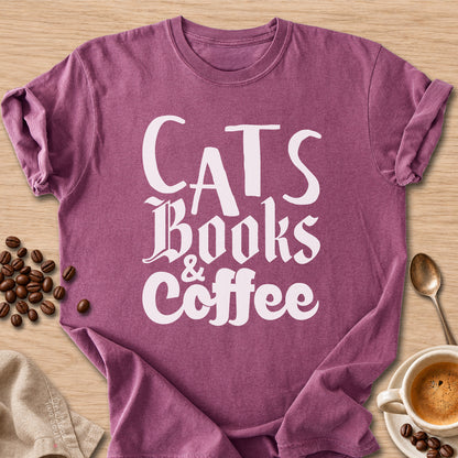 Berry colored Comfort Colors 1717 cotton T-shirt, featuring a "Cats, Books & Coffee" funny cat design illustration. One Meow Two Souls brand.