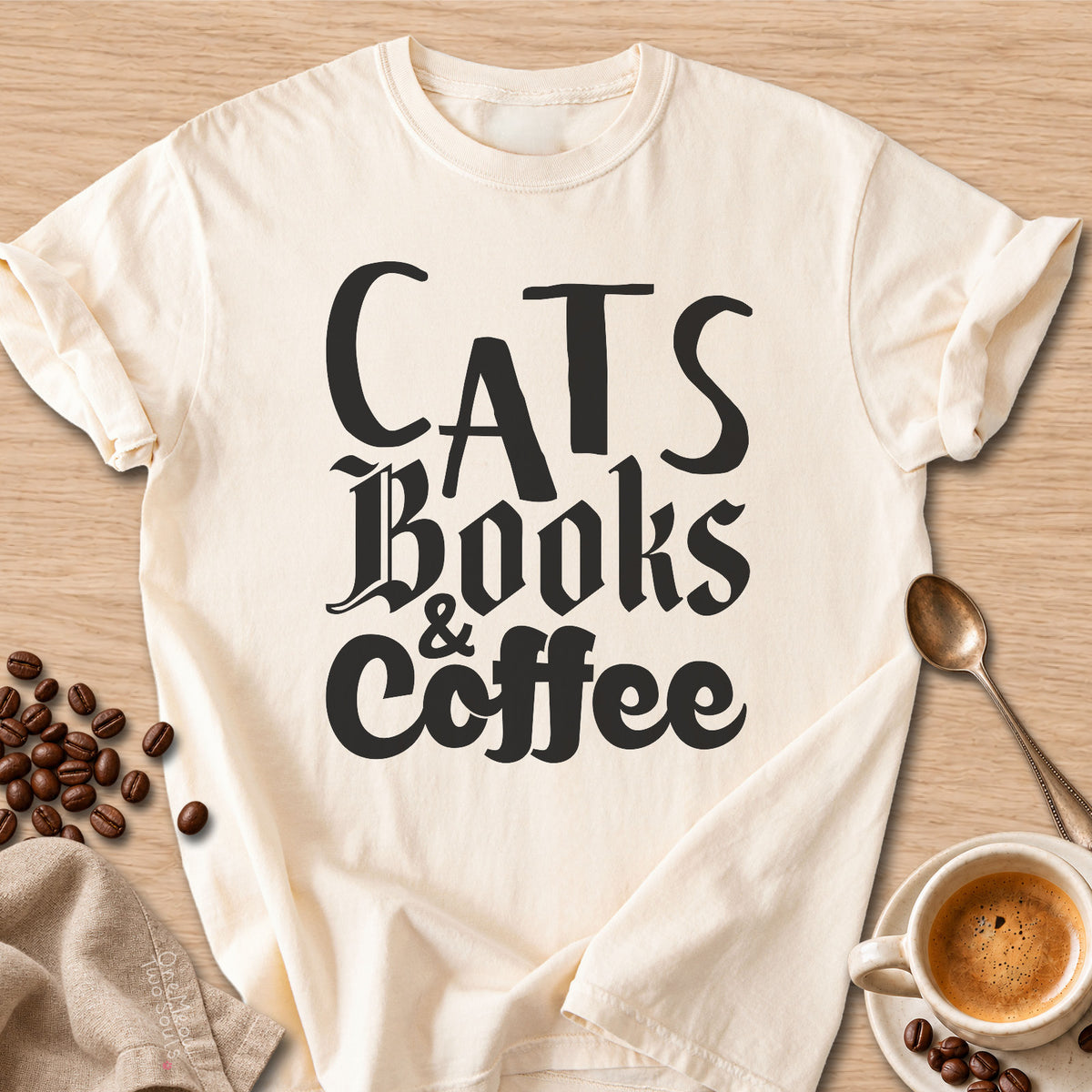 Ivory colored Comfort Colors 1717 cotton T-shirt, featuring a "Cats, Books & Coffee" funny cat design illustration. One Meow Two Souls brand.