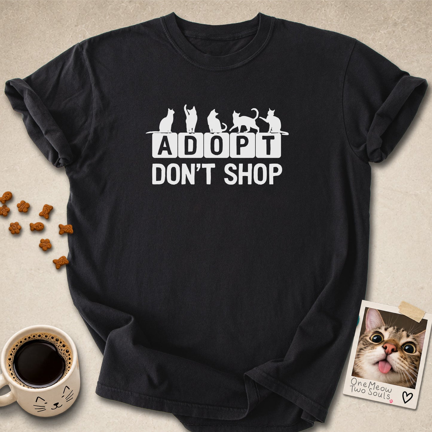 Black colored Comfort Colors 1717 cotton T-shirt, featuring a "Adopt Don't Shop" funny cat design illustration. One Meow Two Souls brand.