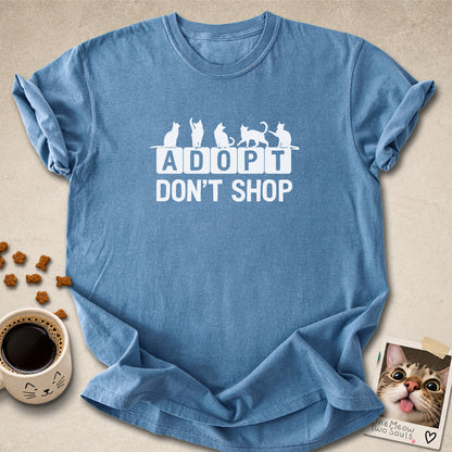 Blue Jean colored Comfort Colors 1717 cotton T-shirt, featuring a "Adopt Don't Shop" funny cat design illustration. One Meow Two Souls brand.