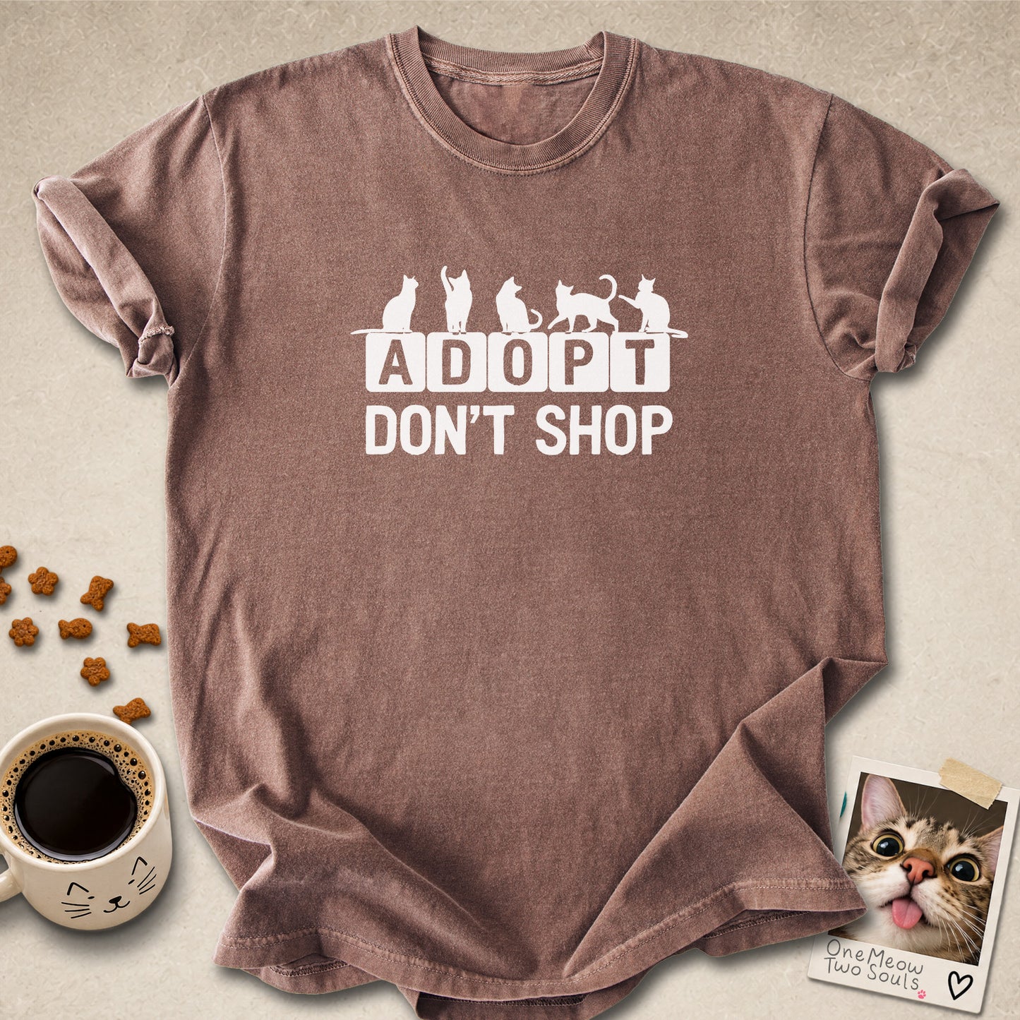 Espresso colored Comfort Colors 1717 cotton T-shirt, featuring a "Adopt Don't Shop" funny cat design illustration. One Meow Two Souls brand.
