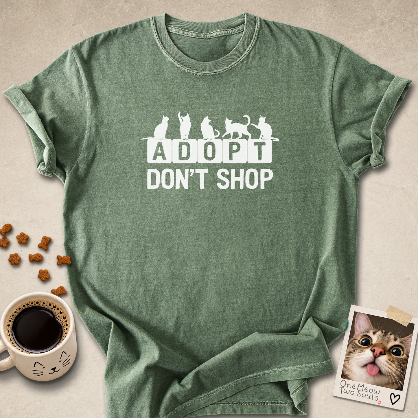 Moss colored Comfort Colors 1717 cotton T-shirt, featuring a "Adopt Don't Shop" funny cat design illustration. One Meow Two Souls brand.