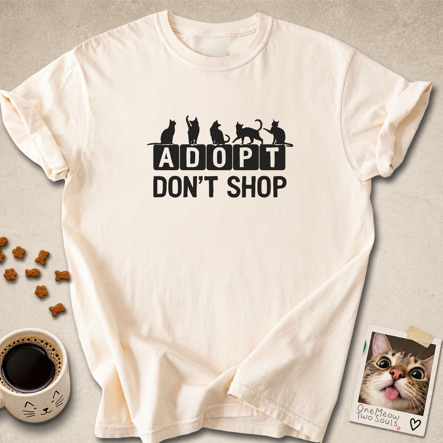 Ivory colored Comfort Colors 1717 cotton T-shirt, featuring a "Adopt Don't Shop" funny cat design illustration. One Meow Two Souls brand.