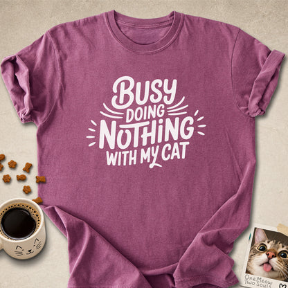 Berry colored Comfort Colors 1717 cotton T-shirt, featuring a "Busy doing nothing with my cat" funny cat design illustration. One Meow Two Souls brand.