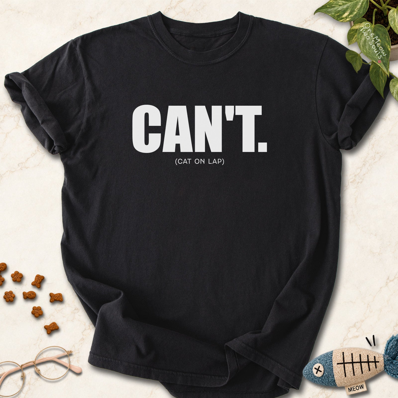 Black colored Comfort Colors 1717 cotton T-shirt, featuring a "Can't. (cat on lap)" funny cat design illustration. One Meow Two Souls brand.