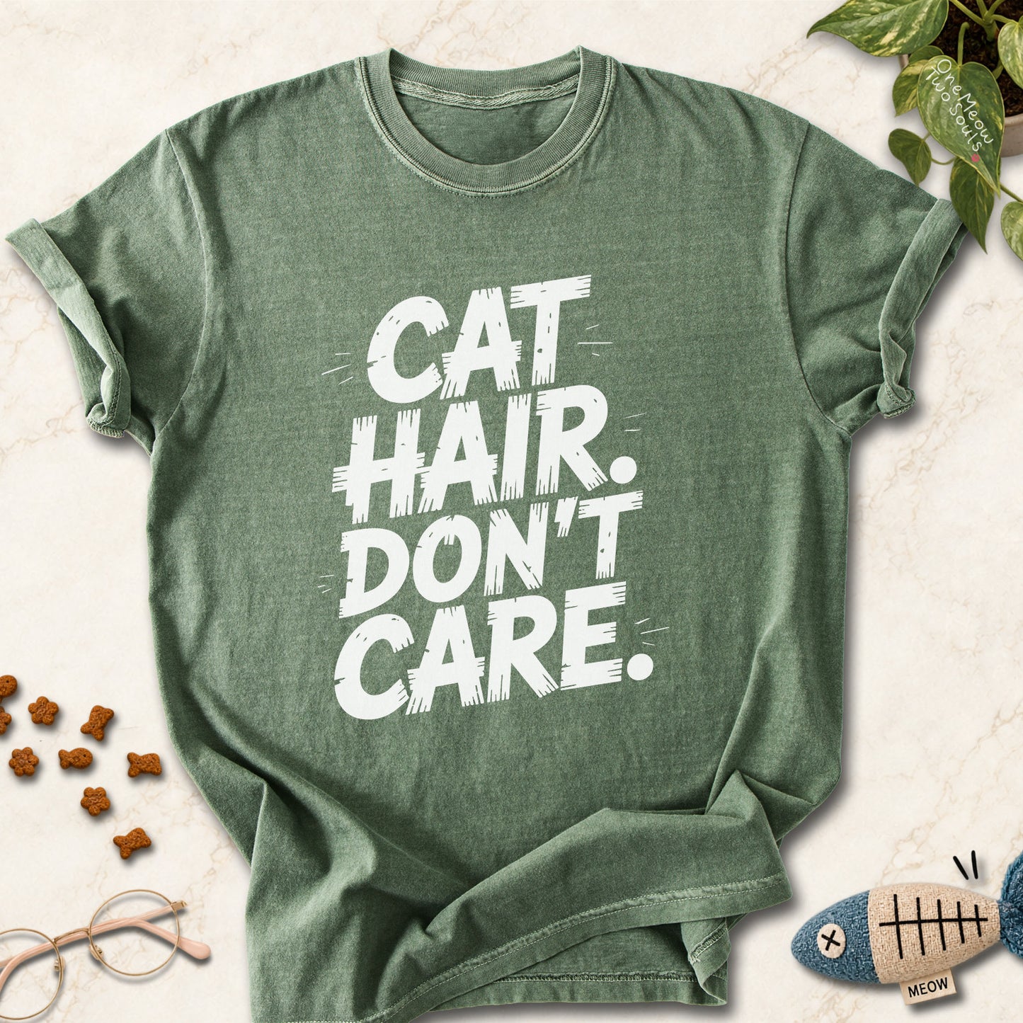 Moss colored Comfort Colors 1717 cotton T-shirt, featuring a "Cat Hair Don't Care" funny cat design illustration. One Meow Two Souls brand.