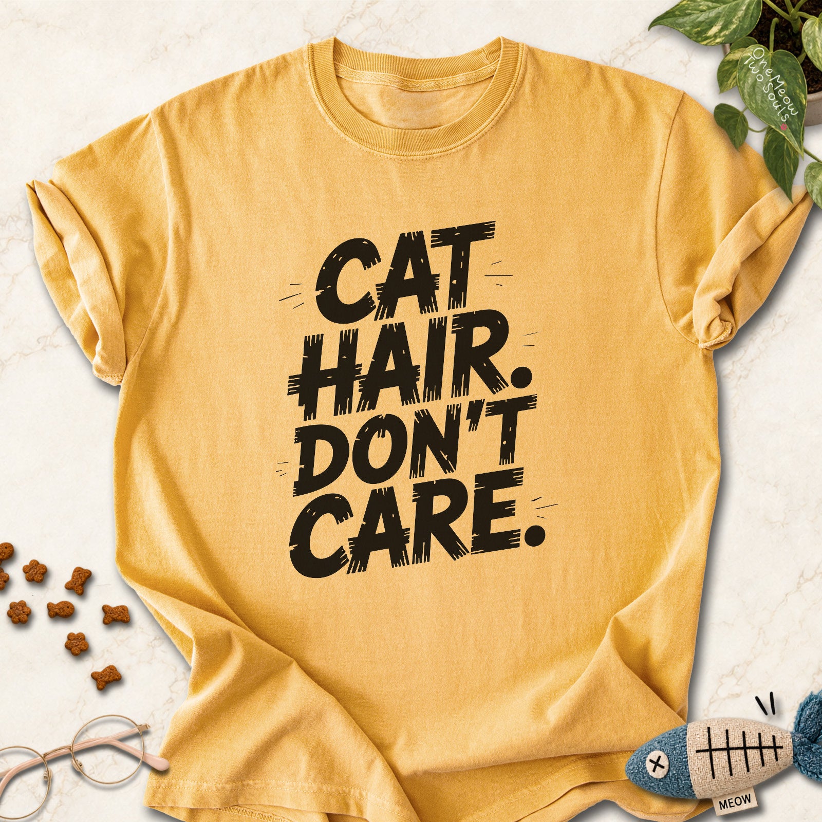 Mustard colored Comfort Colors 1717 cotton T-shirt, featuring a "Cat Hair Don't Care" funny cat design illustration. One Meow Two Souls brand.