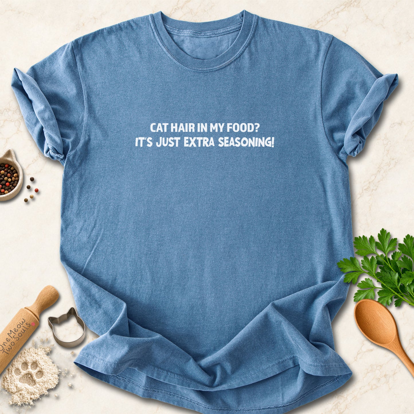 Blue Jean colored Comfort Colors 1717 cotton T-shirt, featuring a "Cat hair in my food? It's just extra seasoning" funny cat design illustration. One Meow Two Souls brand.