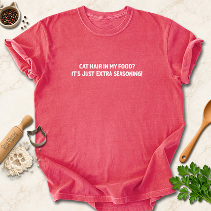 Watermelon colored Comfort Colors 1717 cotton T-shirt, featuring a "Cat hair in my food? It's just extra seasoning" funny cat design illustration. One Meow Two Souls brand.