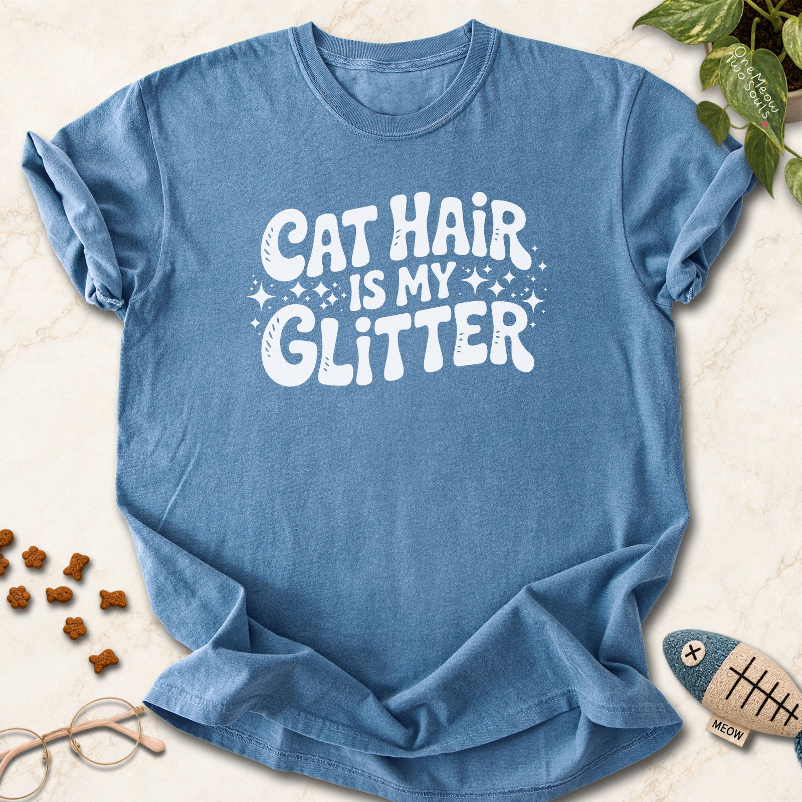 Blue Jean colored Comfort Colors 1717 cotton T-shirt, featuring a "Cat Hair Is My Glitter" funny cat design illustration. One Meow Two Souls brand.