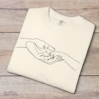 Ivory colored Comfort Colors 1717 cotton T-shirt, featuring a cute cat paw and human hand design illustration. One Meow Two Souls brand.