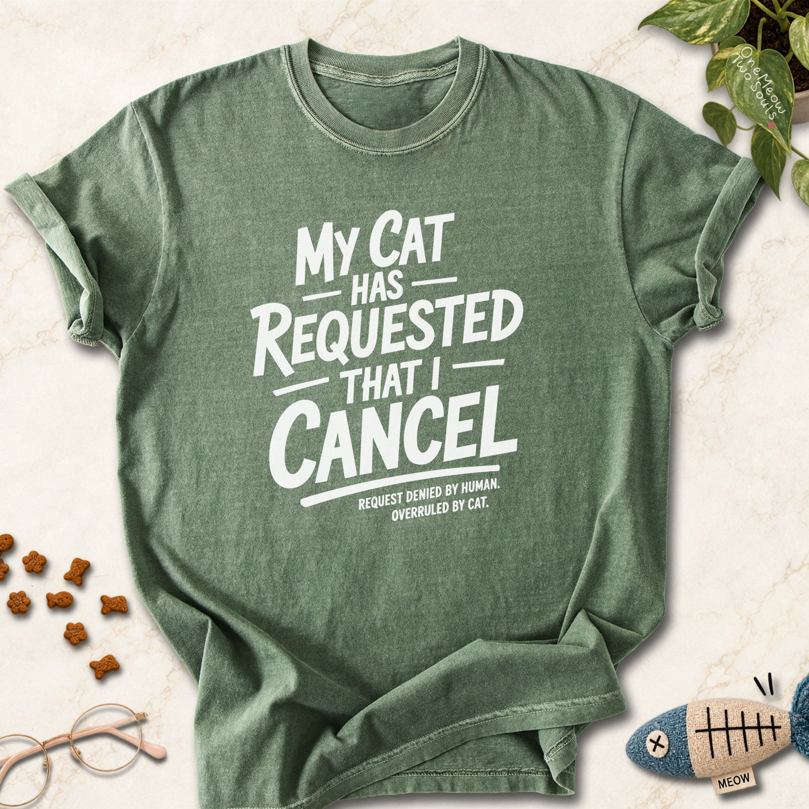 Moss colored Comfort Colors 1717 cotton T-shirt, featuring a "My Cat Has Requested That I Cancel" funny cat design illustration. One Meow Two Souls brand.