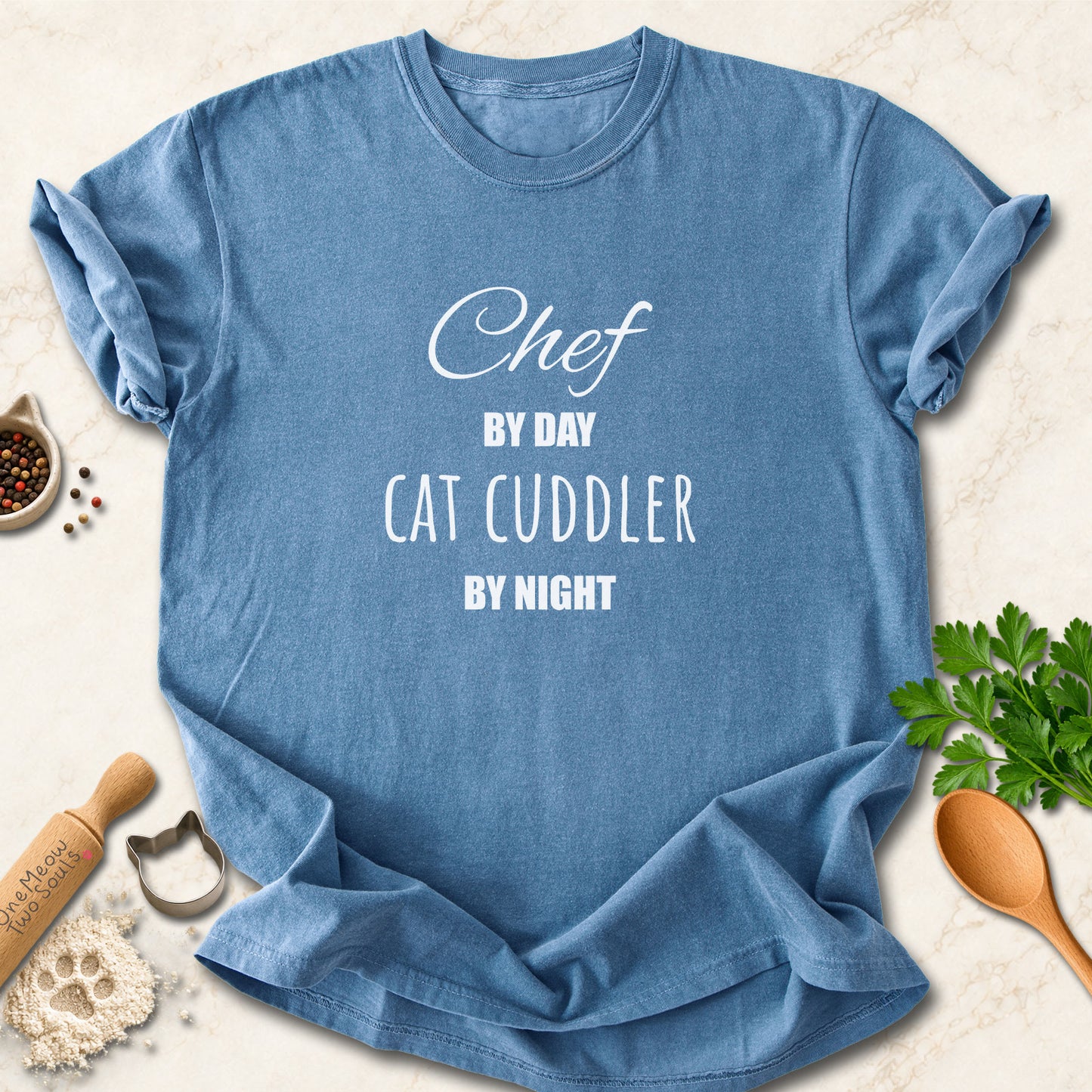 Blue Jean colored Comfort Colors 1717 cotton T-shirt, featuring a "Chef by day, cat cuddler by night" funny cat design illustration. One Meow Two Souls brand.
