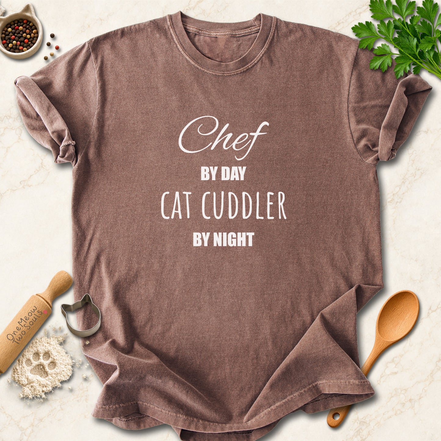 Espresso colored Comfort Colors 1717 cotton T-shirt, featuring a "Chef by day, cat cuddler by night" funny cat design illustration. One Meow Two Souls brand.
