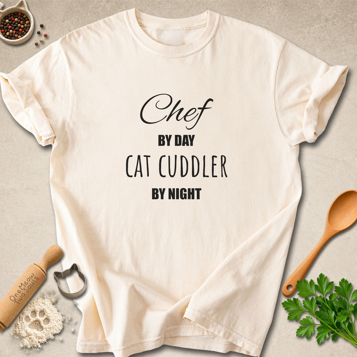 Ivory colored Comfort Colors 1717 cotton T-shirt, featuring a "Chef by day, cat cuddler by night" funny cat design illustration. One Meow Two Souls brand.
