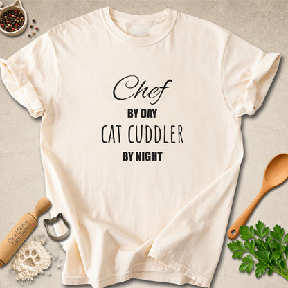 Ivory colored Comfort Colors 1717 cotton T-shirt, featuring a "Chef by day, cat cuddler by night" funny cat design illustration. One Meow Two Souls brand.