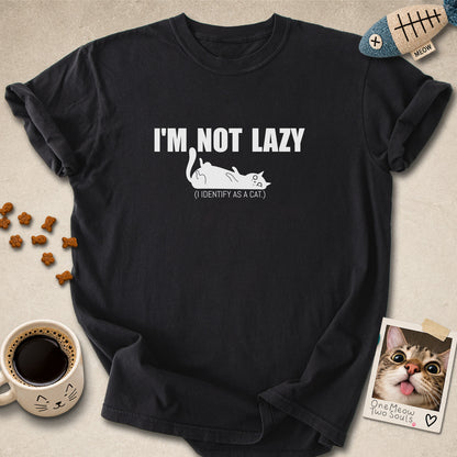Black colored Comfort Colors 1717 cotton T-shirt, featuring a "I'm not lazy, I identify as a cat" funny cat design illustration. One Meow Two Souls brand.
