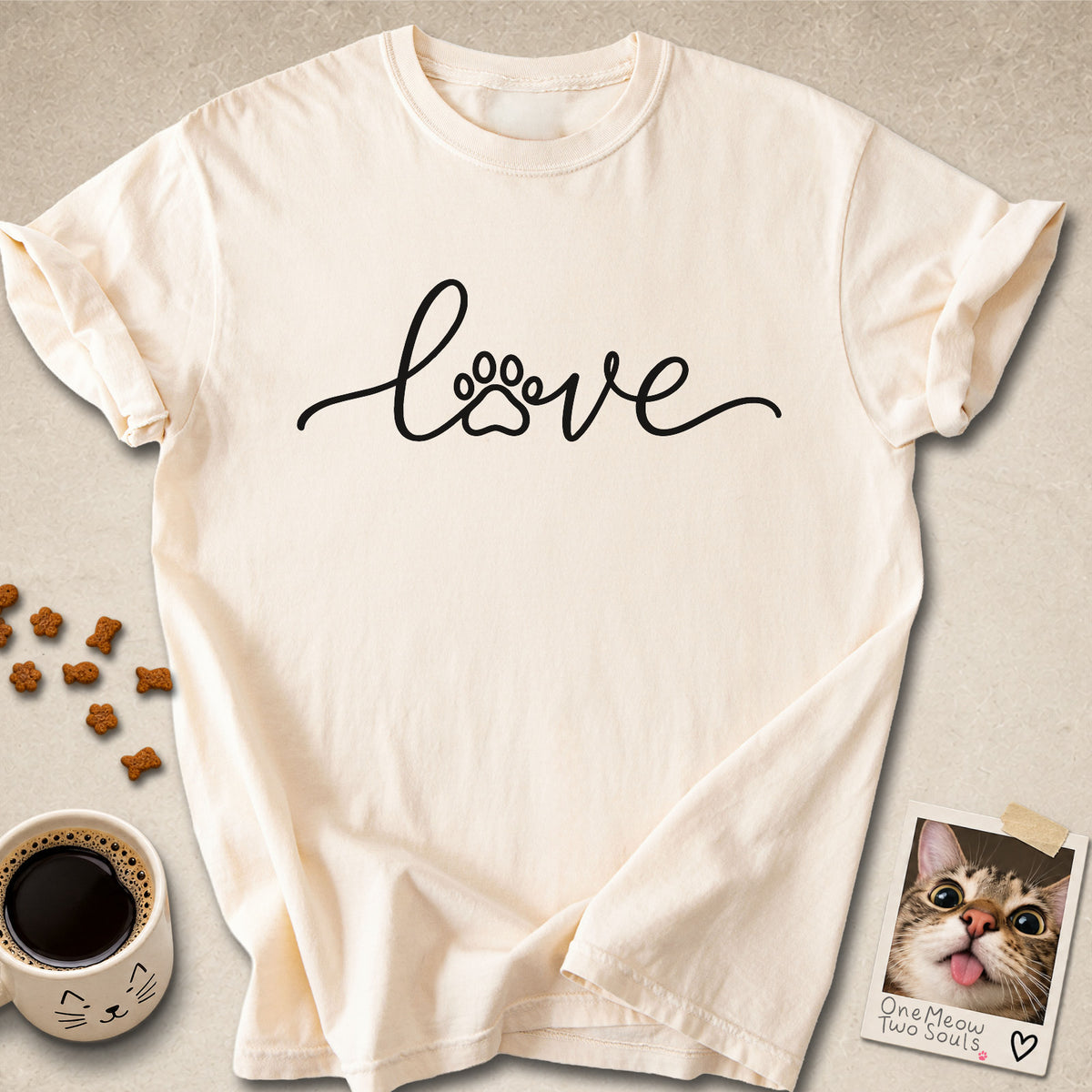 Ivory colored Comfort Colors 1717 cotton T-shirt, featuring a "LOVE" cat paw design illustration. One Meow Two Souls brand.