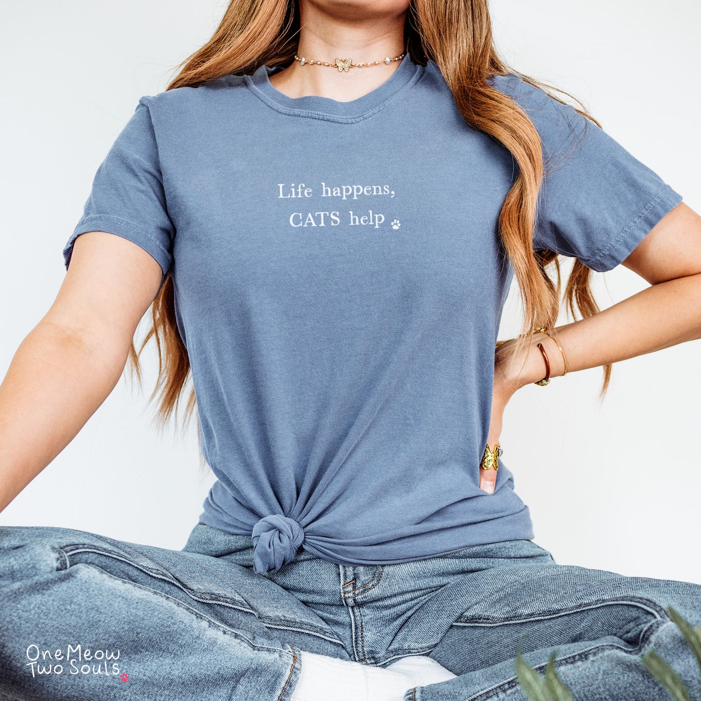 Blue jean colored Comfort Colors 1717 cotton T-shirt, featuring a "Life happens, cats help" funny cat design illustration. One Meow Two Souls brand.