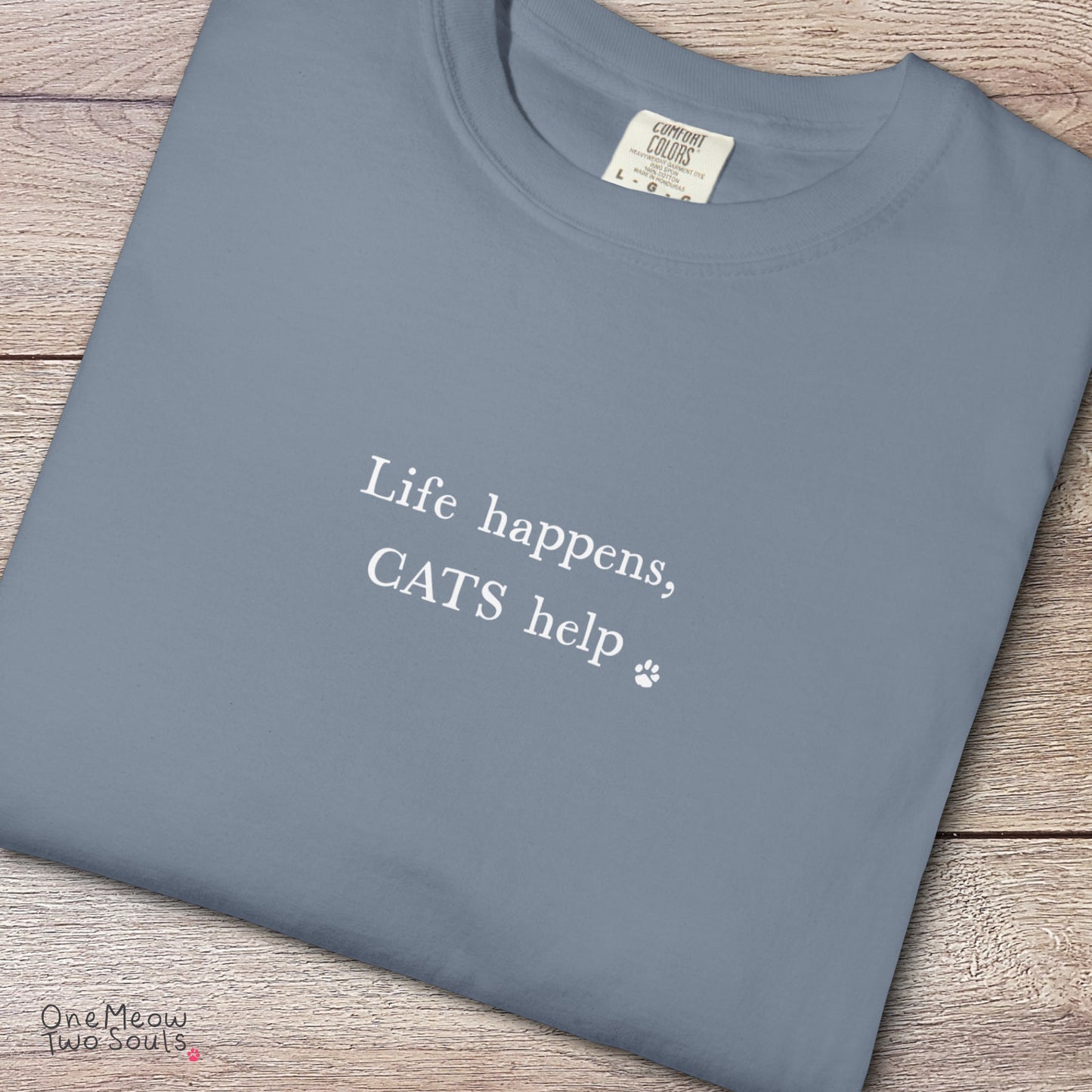Blue jean colored Comfort Colors 1717 cotton T-shirt, featuring a "Life happens, cats help" funny cat design illustration. One Meow Two Souls brand.