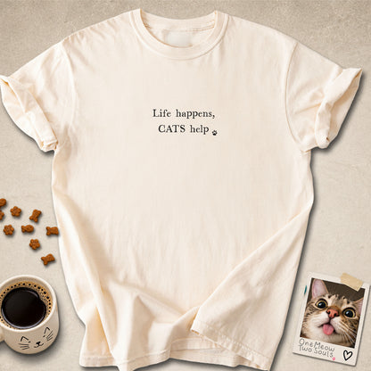 Ivory colored Comfort Colors 1717 cotton T-shirt, featuring a "Life happens, cats help" funny cat design illustration. One Meow Two Souls brand.