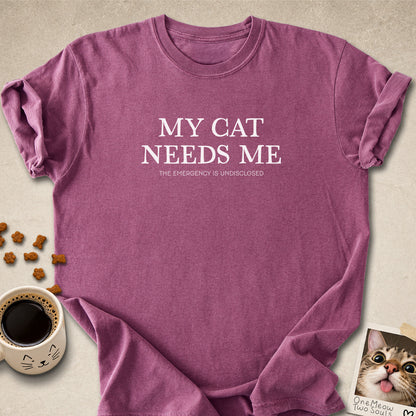 Berry colored Comfort Colors 1717 cotton T-shirt, featuring a "My Cat Needs Me. The Emergency is Undisclosed" funny cat design illustration. One Meow Two Souls brand.