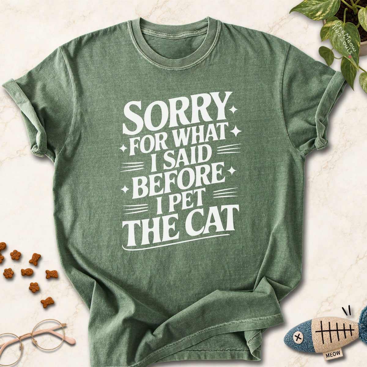 Moss colored Comfort Colors 1717 cotton T-shirt, featuring a "Sorry for what I said before I pet the cat" funny cat design illustration. One Meow Two Souls brand.