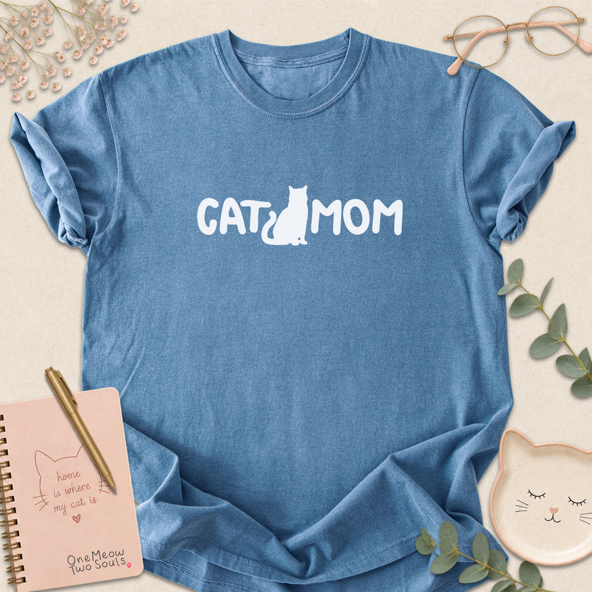 Blue Jean Comfort Colors 1717 t-shirt with a white graphic reading 'CAT MOM'. One Meow Two Souls brand.