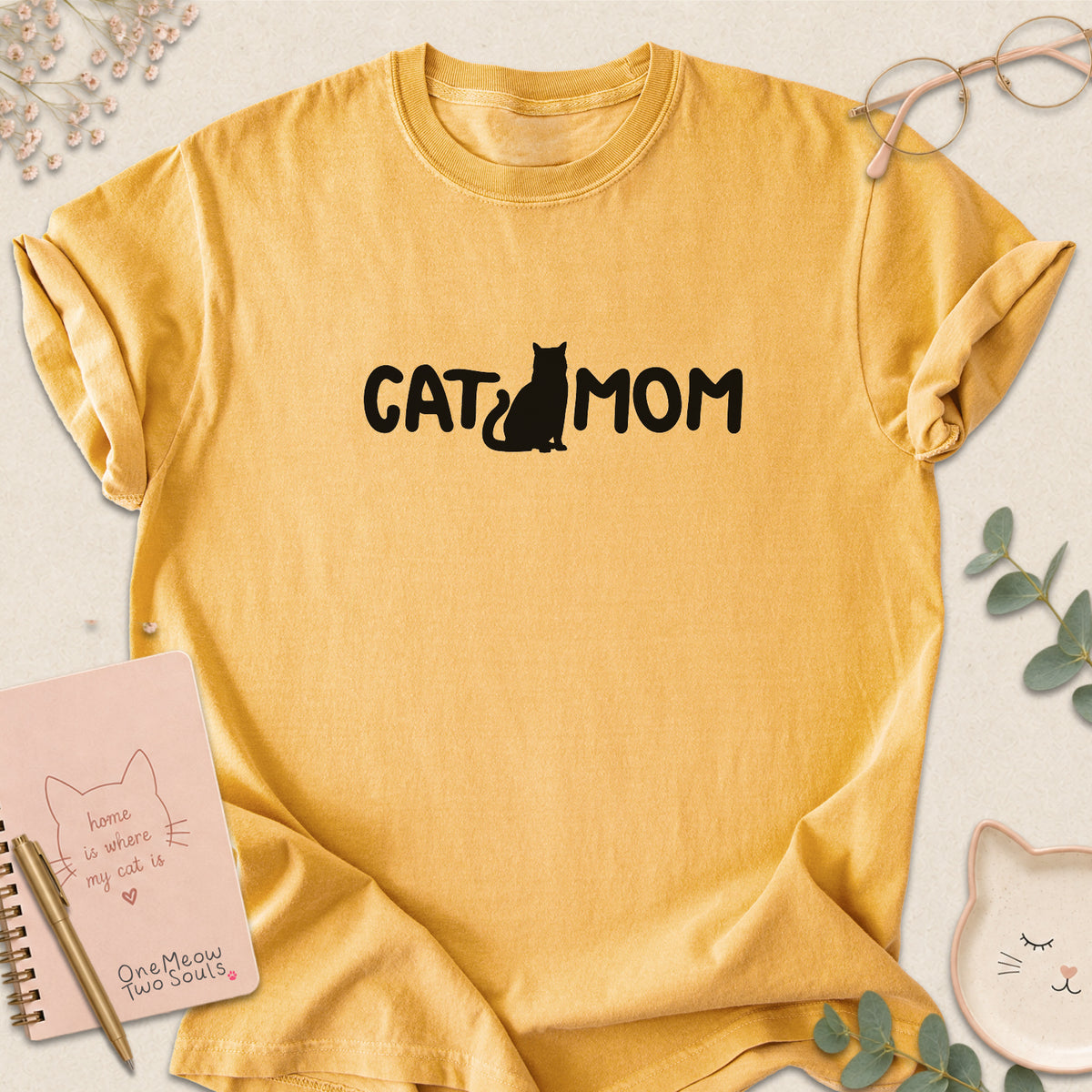 Mustard Comfort Colors 1717 t-shirt with a white graphic reading 'CAT MOM'. One Meow Two Souls brand.