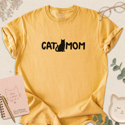 Mustard Comfort Colors 1717 t-shirt with a white graphic reading 'CAT MOM'. One Meow Two Souls brand.