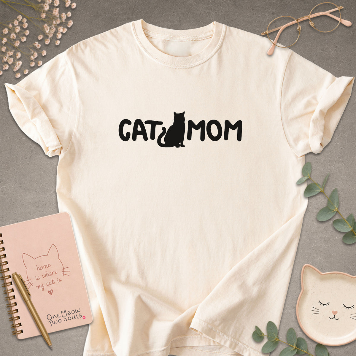 Ivory Comfort Colors 1717 t-shirt with a white graphic reading 'CAT MOM'. One Meow Two Souls brand.