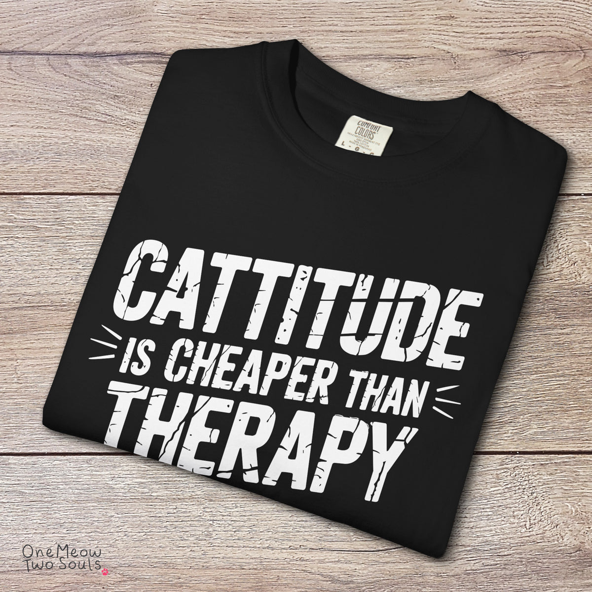 Black colored Comfort Colors 1717 cotton T-shirt, featuring a "Cattitude Is Cheaper Than Therapy" funny cat design illustration. One Meow Two Souls brand.
