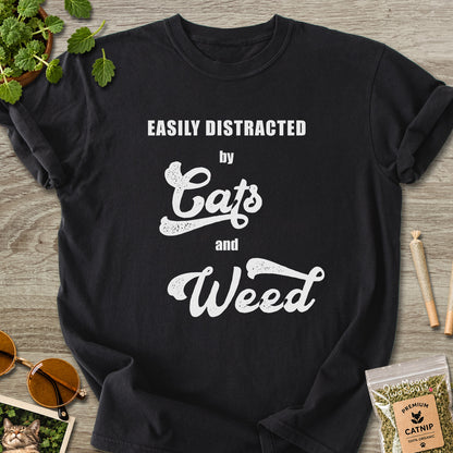 Black colored Comfort Colors 1717 cotton T-shirt, featuring a "Easily Distracted by Cats and Weed" funny cat design illustration. One Meow Two Souls brand.