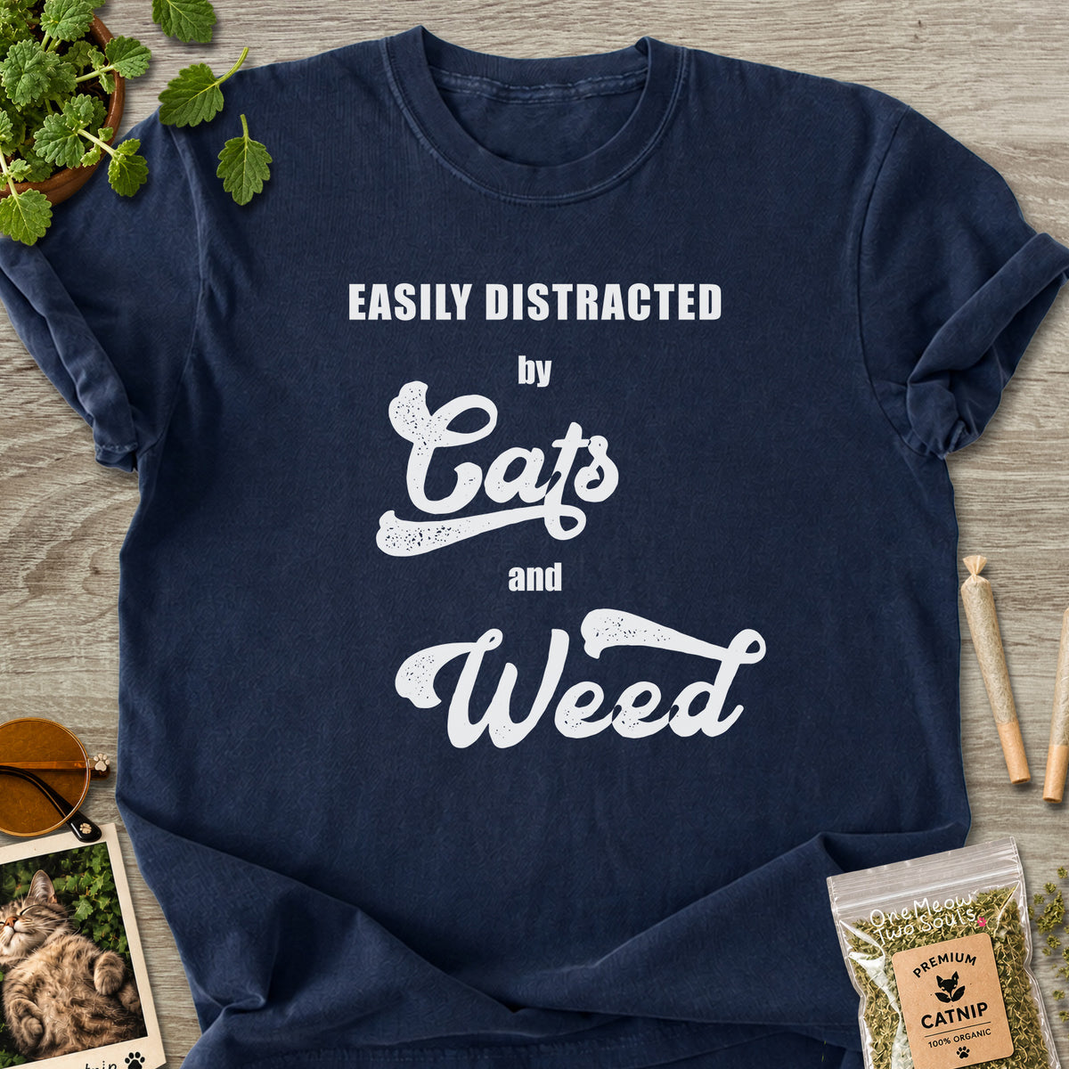 Navy colored Comfort Colors 1717 cotton T-shirt, featuring a "Easily Distracted by Cats and Weed" funny cat design illustration. One Meow Two Souls brand.
