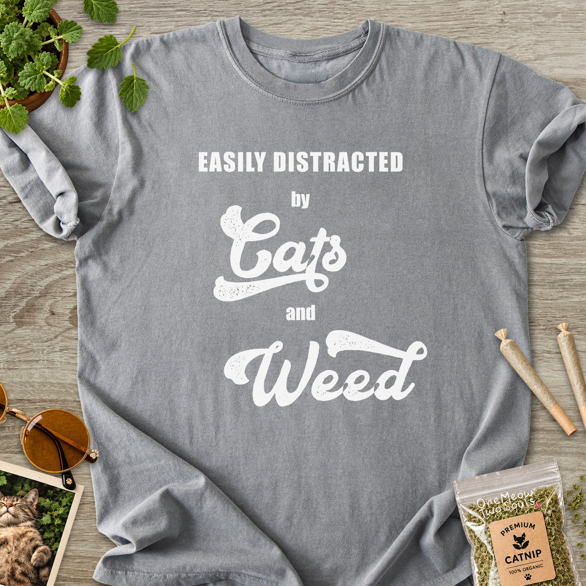 Grey colored Comfort Colors 1717 cotton T-shirt, featuring a "Easily Distracted by Cats and Weed" funny cat design illustration. One Meow Two Souls brand.