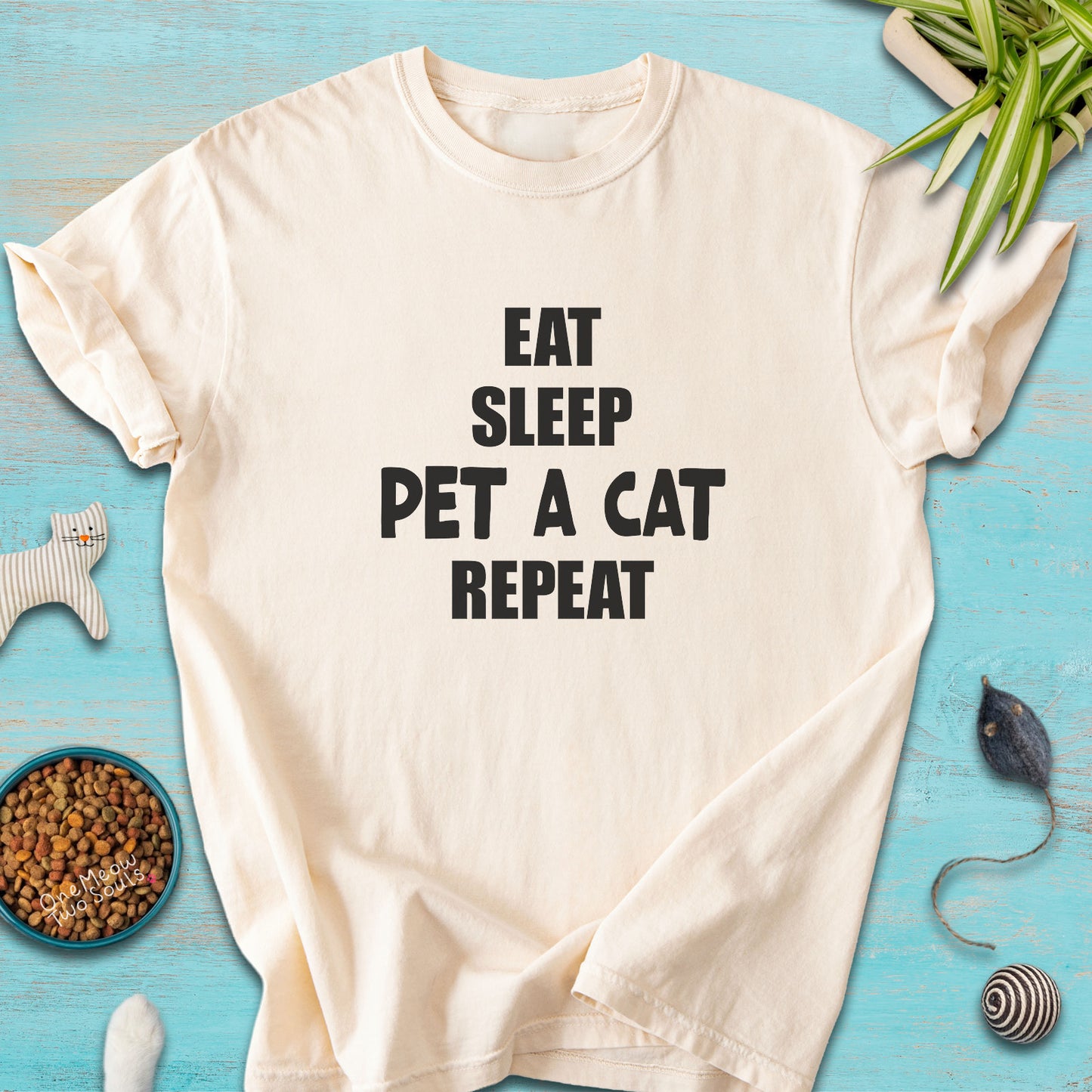 Ivory colored Comfort Colors 1717 t-cotton shirt with a "Eat Sleep Pet a Cat Repeat" design. One Meow Two Souls brand.