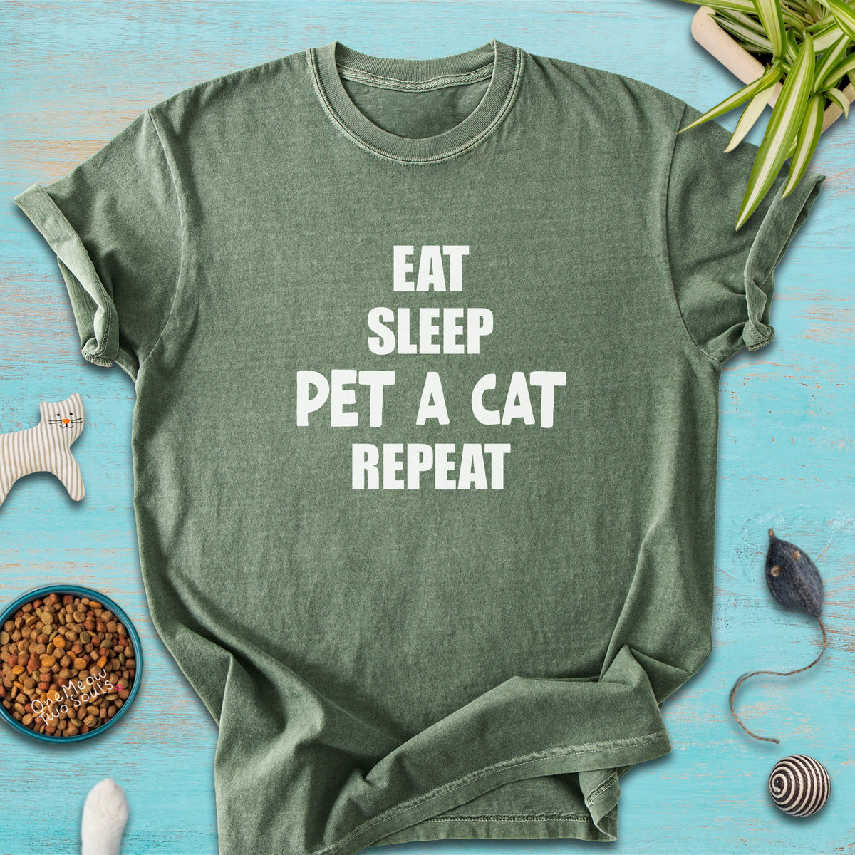 Moss colored Comfort Colors 1717 t-cotton shirt with a "Eat Sleep Pet a Cat Repeat" design. One Meow Two Souls brand.