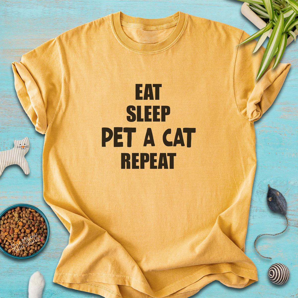 Mustard colored Comfort Colors 1717 t-cotton shirt with a "Eat Sleep Pet a Cat Repeat" design. One Meow Two Souls brand.