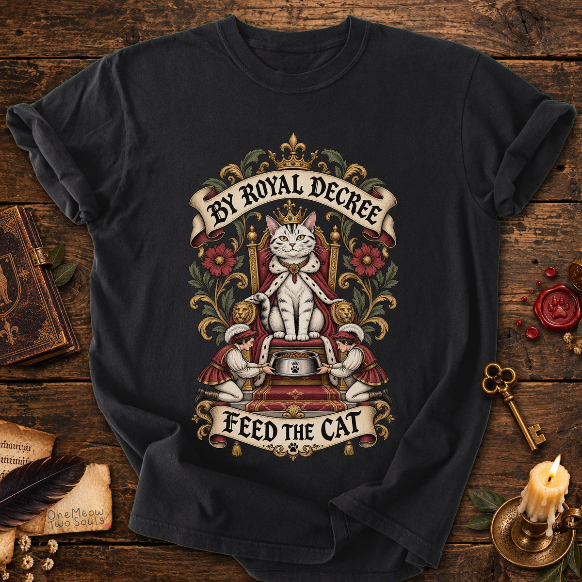 Black colored Comfort Colors 1717 cotton T-shirt, featuring a "By Royal Decree - Feed The Cat" funny cat design illustration. One Meow Two Souls brand.
