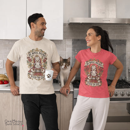 A man and a woman standing in a kitchen, both wearing matching graphic t-shirts with a cat design. The man's shirt is cream-colored and the woman's is coral pink.
Ivory and Watermelon colored Comfort Colors 1717 cotton T-shirt, featuring a "By Royal Decree - Feed The Cat" funny cat design illustration. One Meow Two Souls brand.