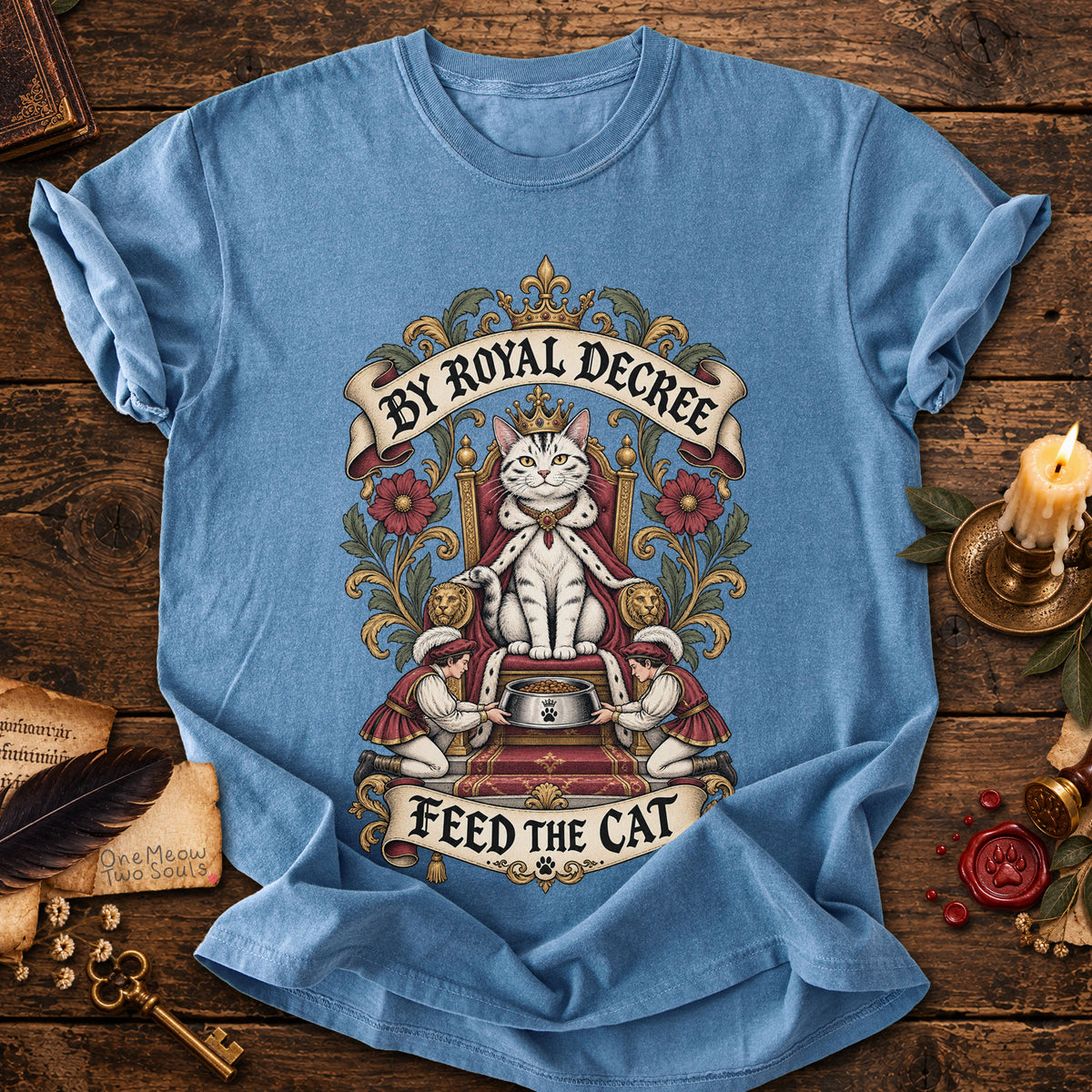 Blue Jean colored Comfort Colors 1717 cotton T-shirt, featuring a "By Royal Decree - Feed The Cat" funny cat design illustration. One Meow Two Souls brand.