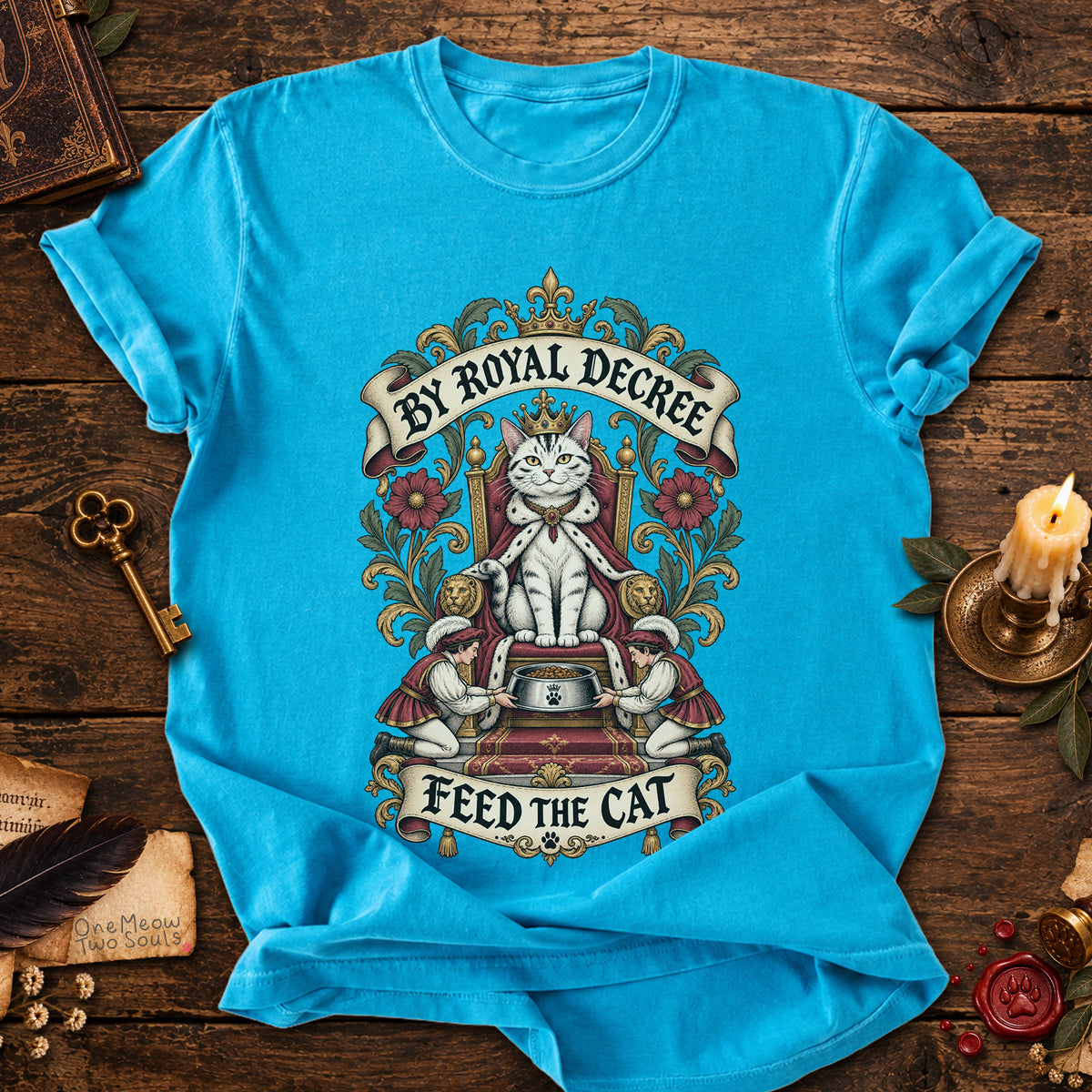 Sapphire colored Comfort Colors 1717 cotton T-shirt, featuring a "By Royal Decree - Feed The Cat" funny cat design illustration. One Meow Two Souls brand.