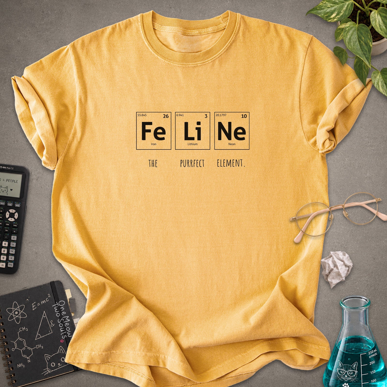 Mustard colored Comfort Colors 1717 cotton T-shirt, presenting a "FeLiNe The Purrfect Lelement" funny Chemistry cat design. One Meow Two Souls brand.