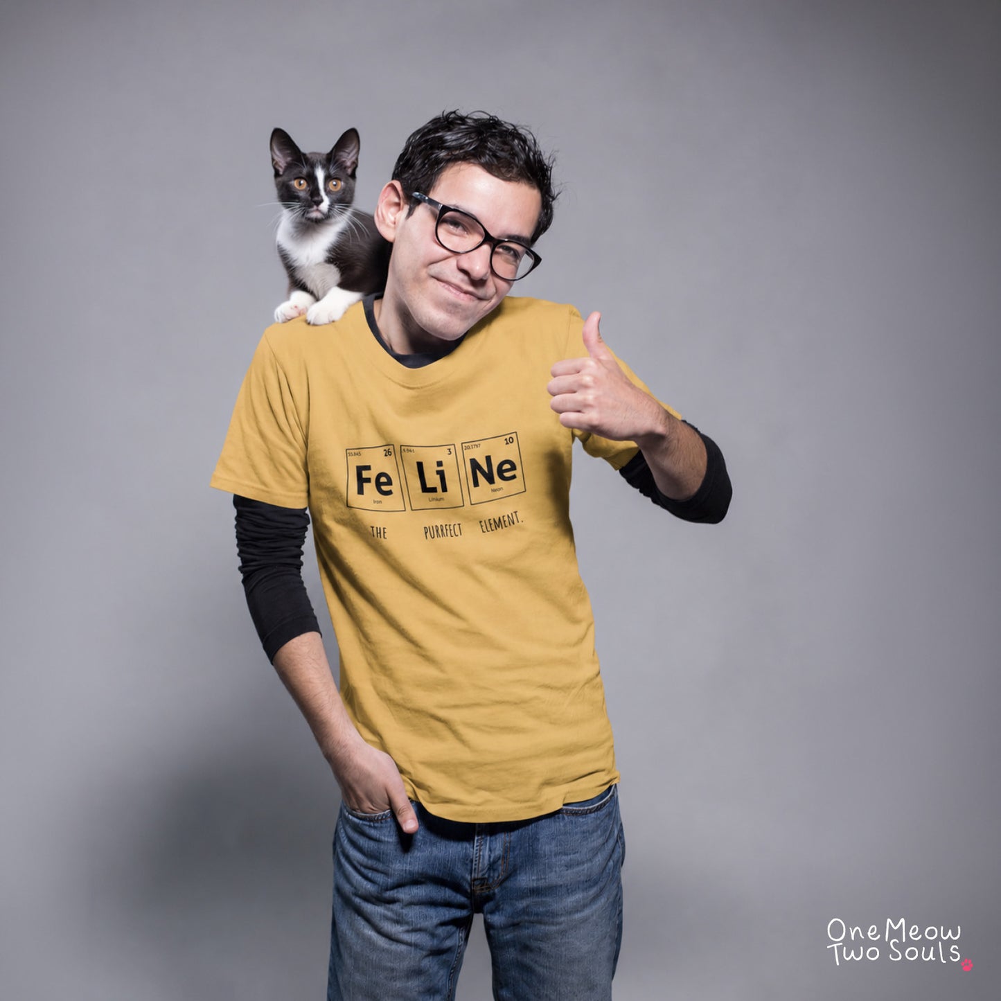Mustard colored Comfort Colors 1717 cotton T-shirt, presenting a "FeLiNe The Purrfect Lelement" funny Chemistry cat design. One Meow Two Souls brand.