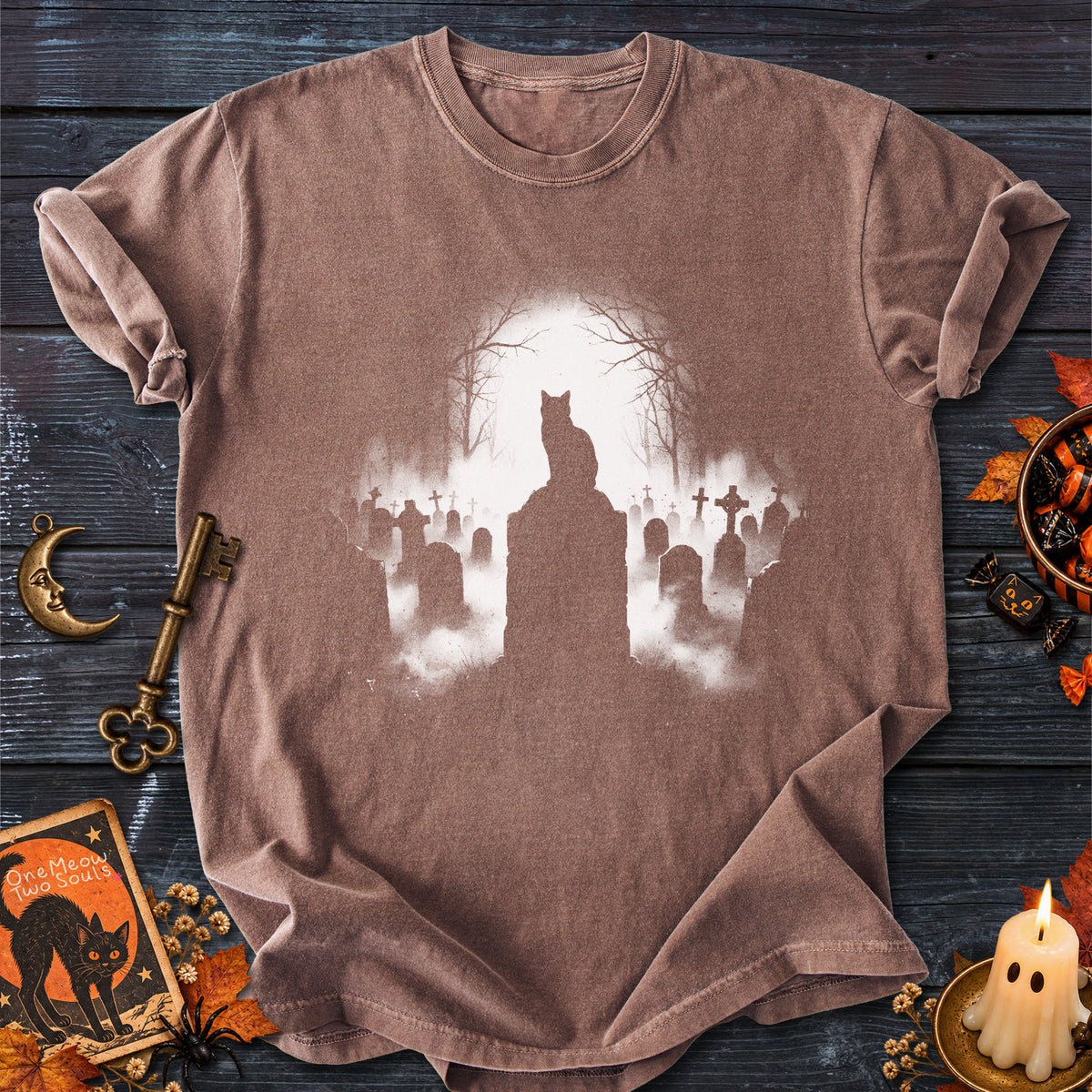 Espresso colored Comfort Colors 1717 cotton T-shirt, featuring a spooky graveyard Halloween cat design illustration. One Meow Two Souls brand.