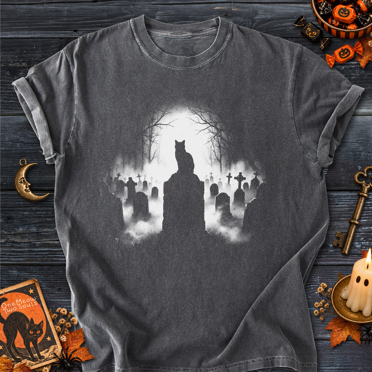 Pepper colored Comfort Colors 1717 cotton T-shirt, featuring a spooky graveyard Halloween cat design illustration. One Meow Two Souls brand.