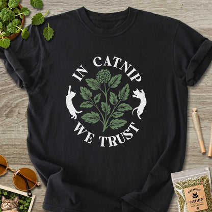 Black colored Comfort Colors 1717 cotton T-shirt, featuring a "In Catnip We Trust" funny cat design illustration. One Meow Two Souls brand.